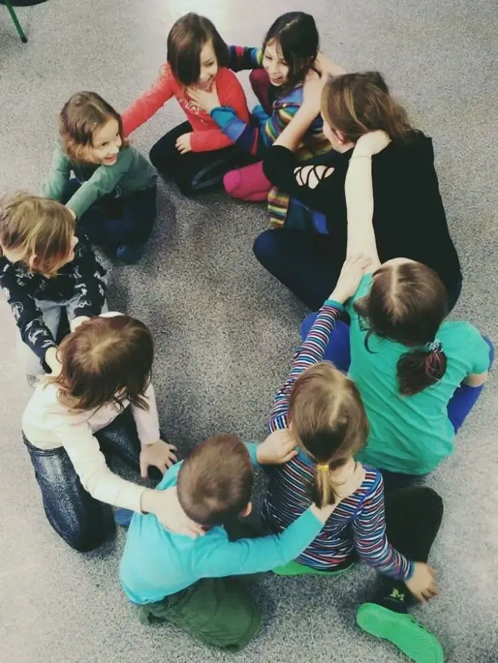 Uczniowie siedzą w kręgu podczas zebrania