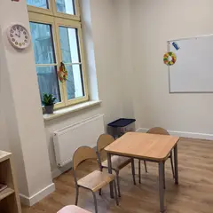 Kącik ze stolikiem przy oknie, zegar i godło